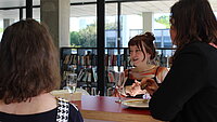 Studentin Helena im Gespräch mit zwei weiteren Studentinnen.